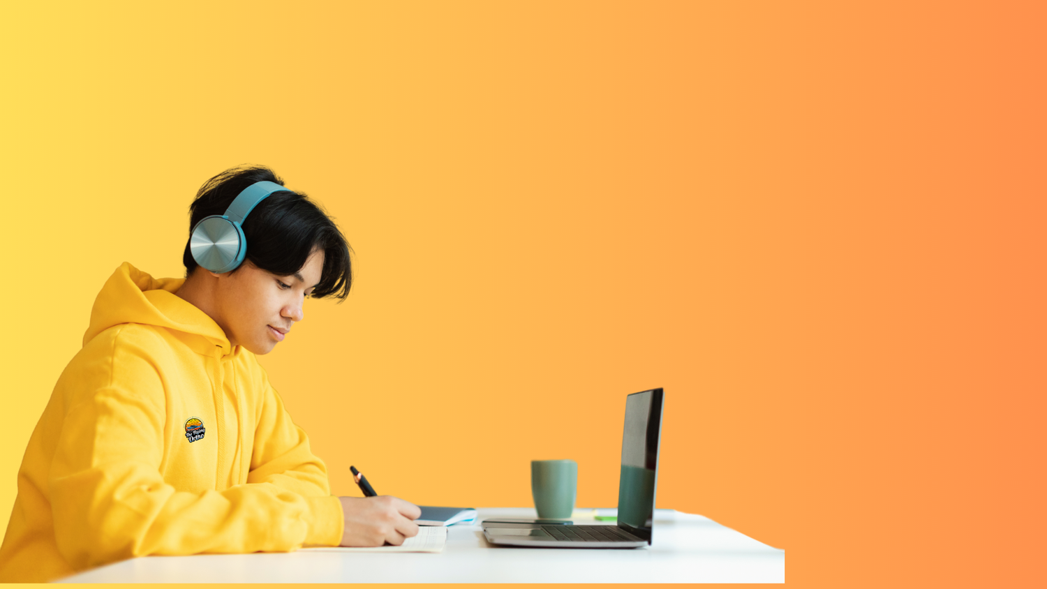 Person in yellow hoodie with headphones using a laptop and taking notes on an orange background